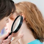 doctor checking lump behind ear